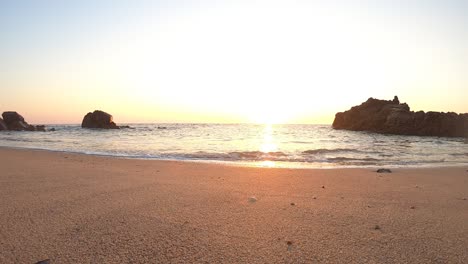 low ground pov, calm ocean waves sound under warm sunset in portuguese beach