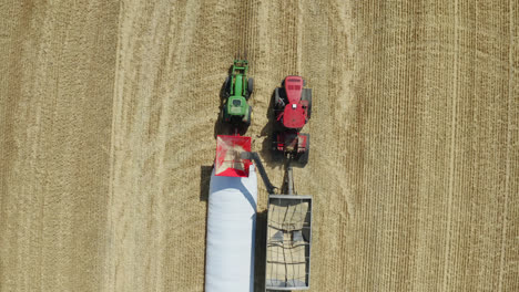 Zoom-A-Vista-De-Pájaro-Sobre-Equipos-Agrícolas-Cosechando-Granos,-Saskatchewan,-Canadá