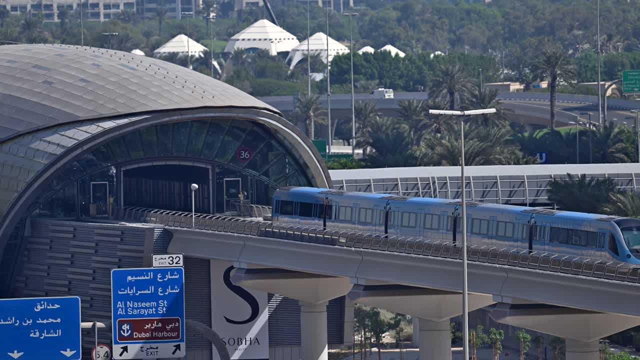 A Dubai Metro train approaches the station, heading to its next stop along Sheikh Zayed Road in Dubai, UAE