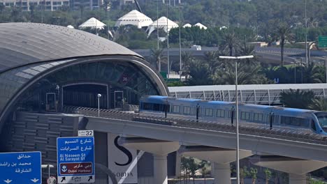 a dubai metro train approaches the station, heading to its next stop along sheikh zayed road in dubai, uae