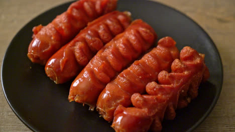 deep-fried-sausage-skewer-on-black-plate