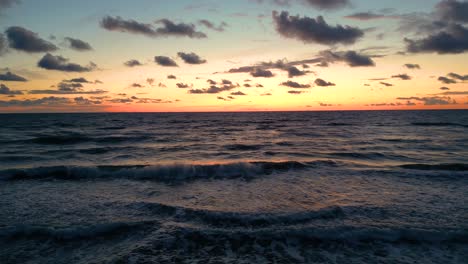 Tropical-golden-sunset-over-ocean-water-slow-motion-aerial-view