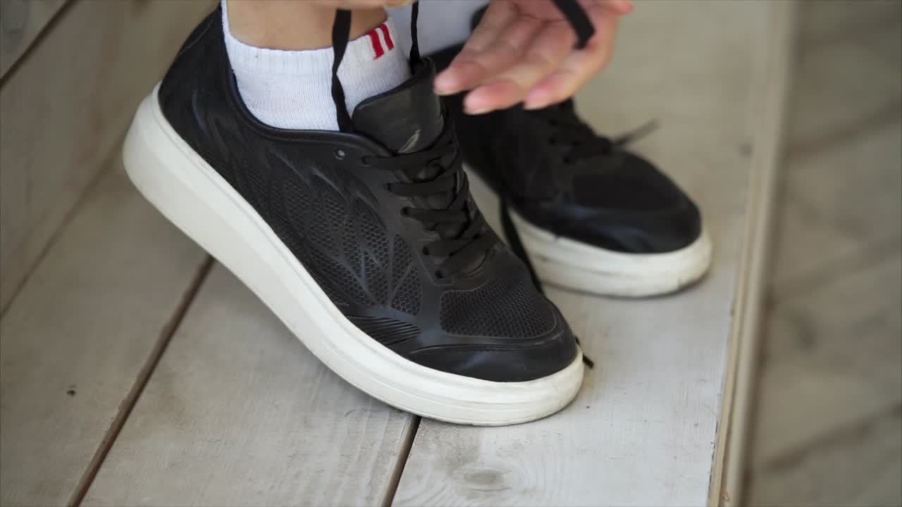 Woman Tying Up Black Sneakers