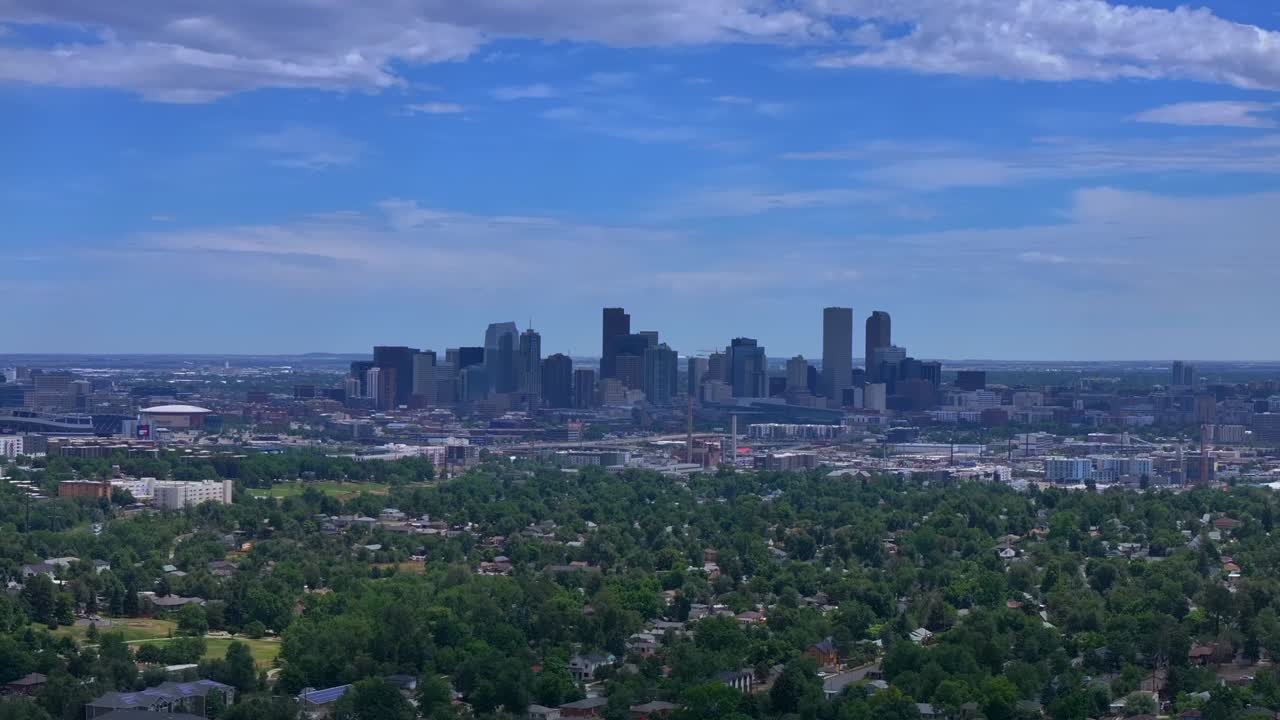 Summer downtown Denver city skyscrapers Colorado aerial drone forward traffic cars highway Mile High neighborhood homes blue skies cloudy 6th avenue colfax RTD line front range foothills landscape