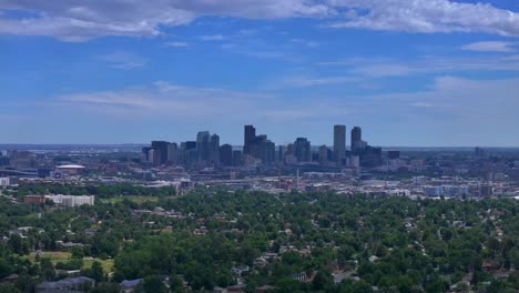summer downtown denver city skyscrapers colorado aerial drone forward traffic cars highway mile high neighborhood homes blue skies cloudy 6th avenue colfax rtd line front range foothills landscape