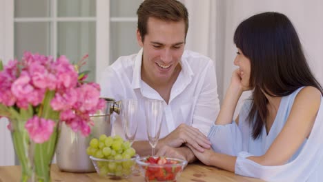 cute mixed couple enjoying wine and fruit together