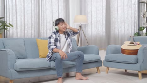 teenager dancing and listening to music on a sofa