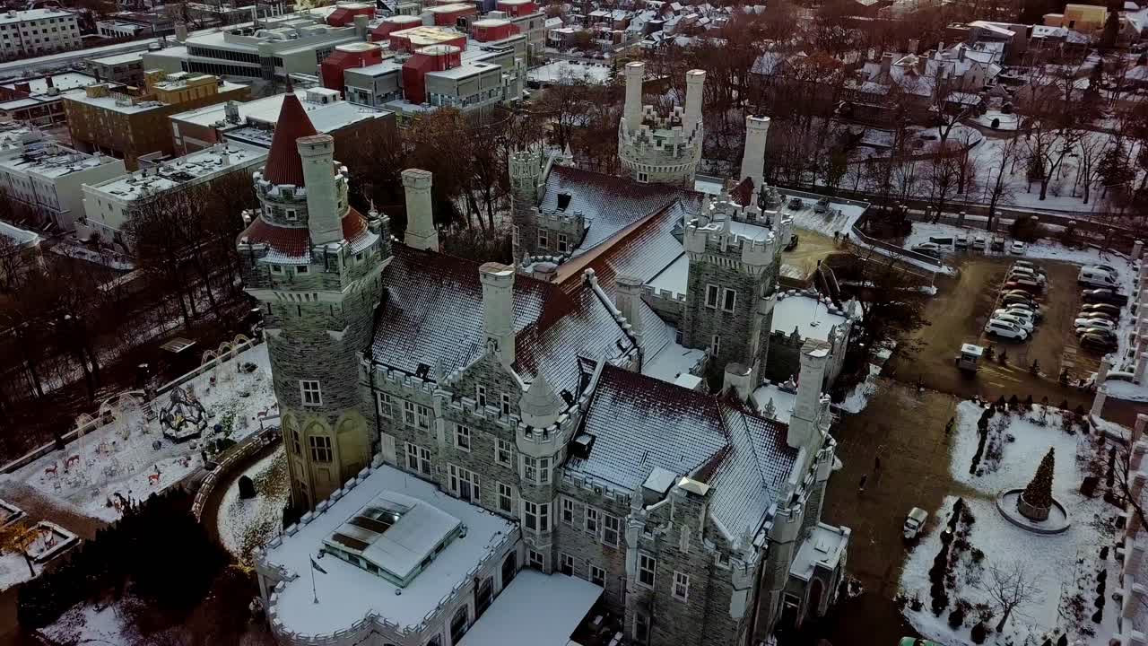 Fairytale Castle in Snow at Christmas Holiday, Slow Drone Pull Back. Cinematic Overhead View of the Towers and Red Tile Roof of a Beautiful Disney Style Palace in Toronto Ontario Canada in December