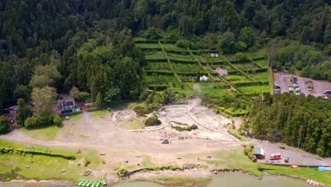 Zooming-flyover-of-steaming-geothermal-hot-springs-in-Furnas,-Azores