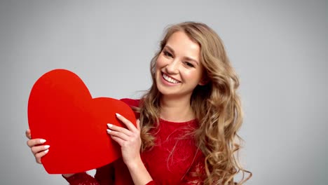 mujer juguetona mostrando la tarjeta de san valentín