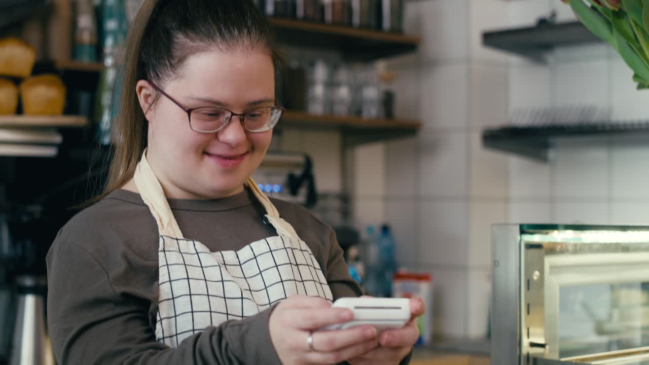 hombre caucásico con síndrome de down aceptando el pago sin contacto en el café