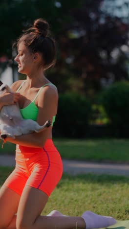mujer jugando con un pug en un parque