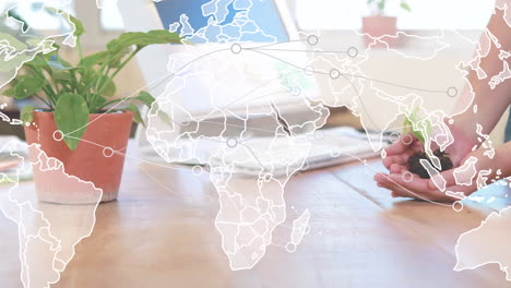 animación de conexiones y mapa del mundo sobre las manos de una mujer caucásica sosteniendo una planta
