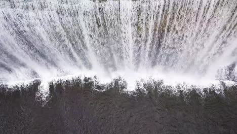 vista de un avión no tripulado de un pájaro de una amplia cascada con una gran gota en la isla norte, nueva zelanda