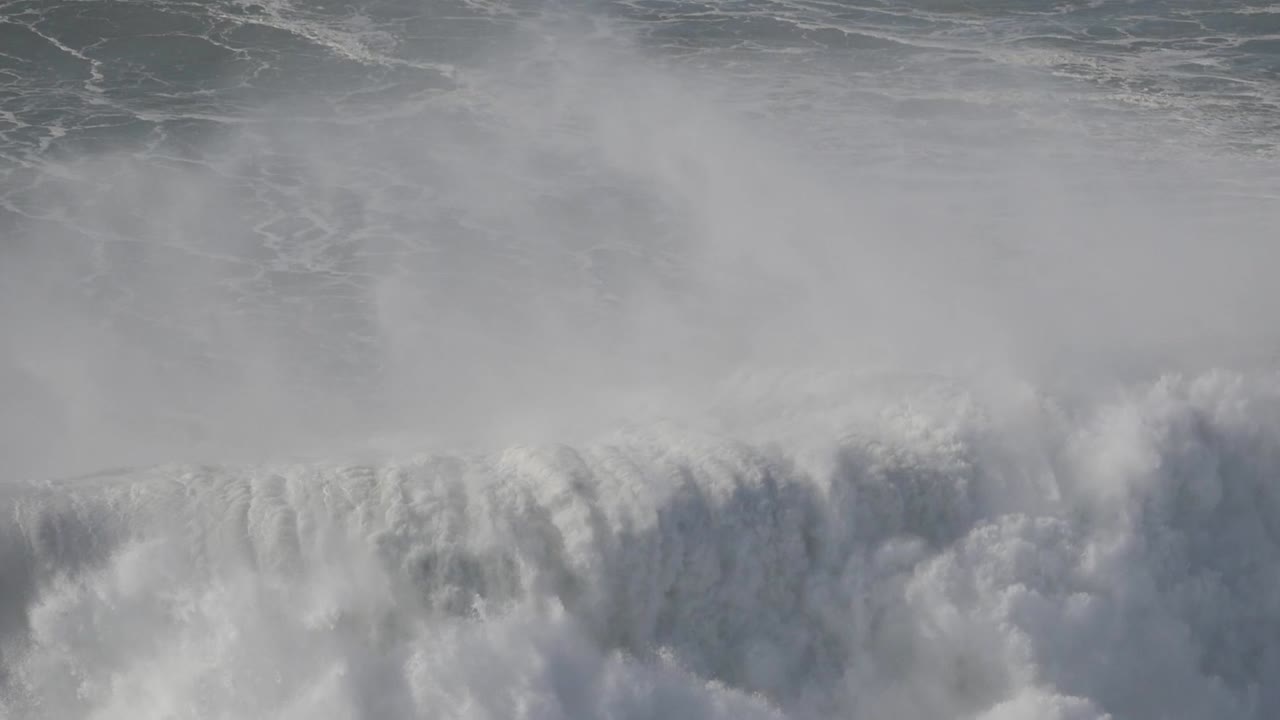 Enormous wave crashing along the shores of Nazare, Portugal, creating foam