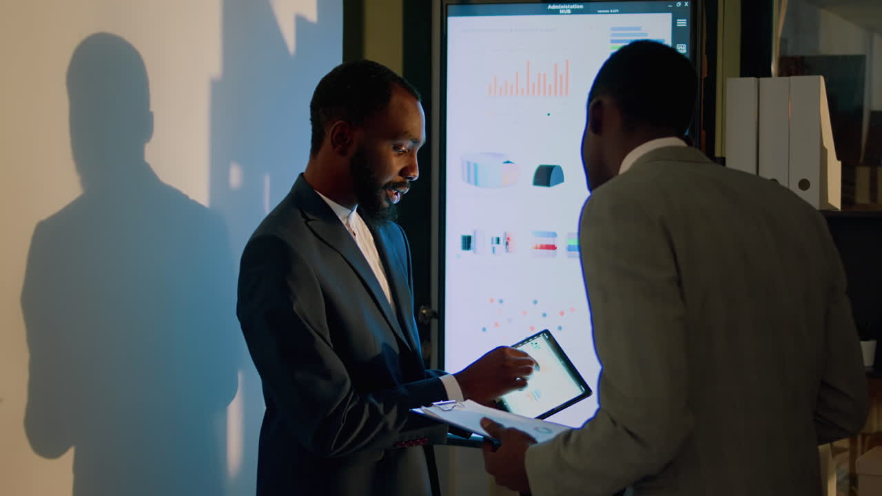 Businessmen Discussing Data on a Presentation Screen