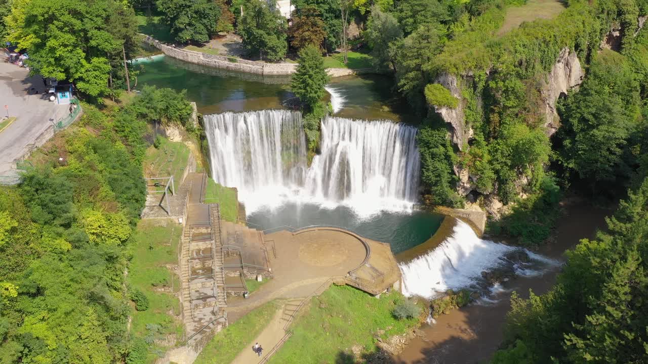 Famous Jajce Waterfall in Bosnia and Herzegovina with visitor platform below, Aerial flyover shot