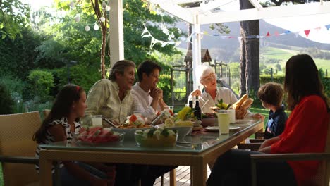 Familia-Comiendo-Afuera-Juntos-En-Verano