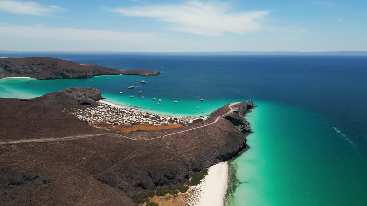 Clear turquoise waters, boats docked on a beach in Tecolandra, La Paz, Mexico
