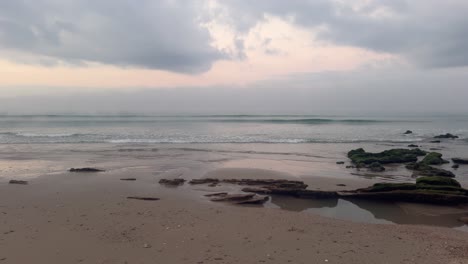 Una-Playa-Prístina-Con-Olas-Que-Llegan-Suavemente-En-Un-Día-Nublado