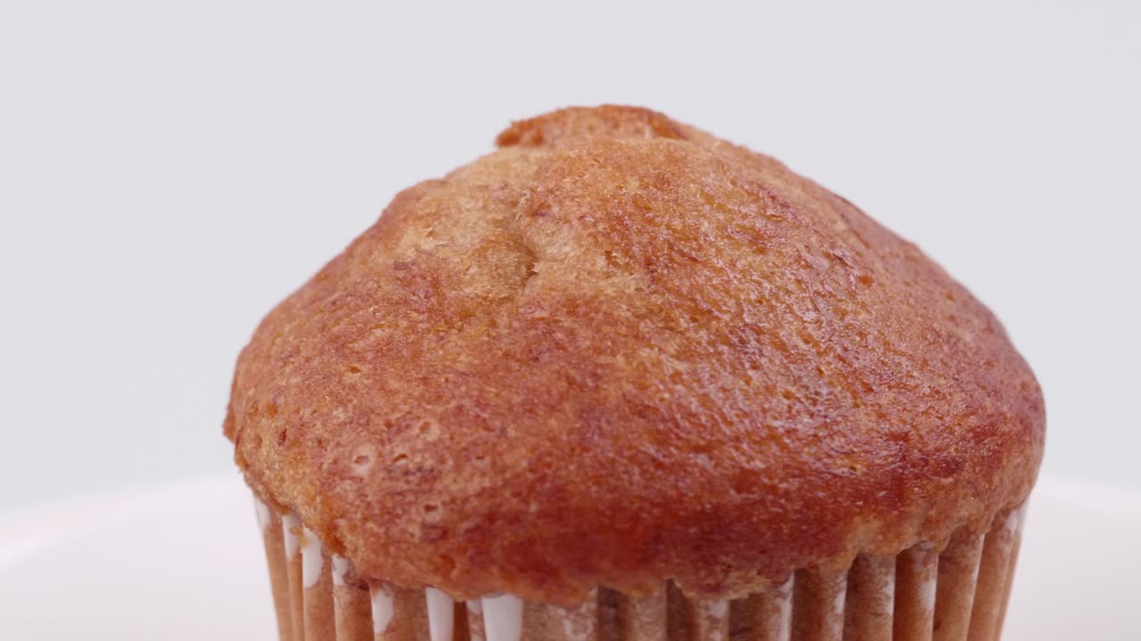 흰색 배경에 얕은 포커스가 있고 천천히 회전하는 머핀 바나나