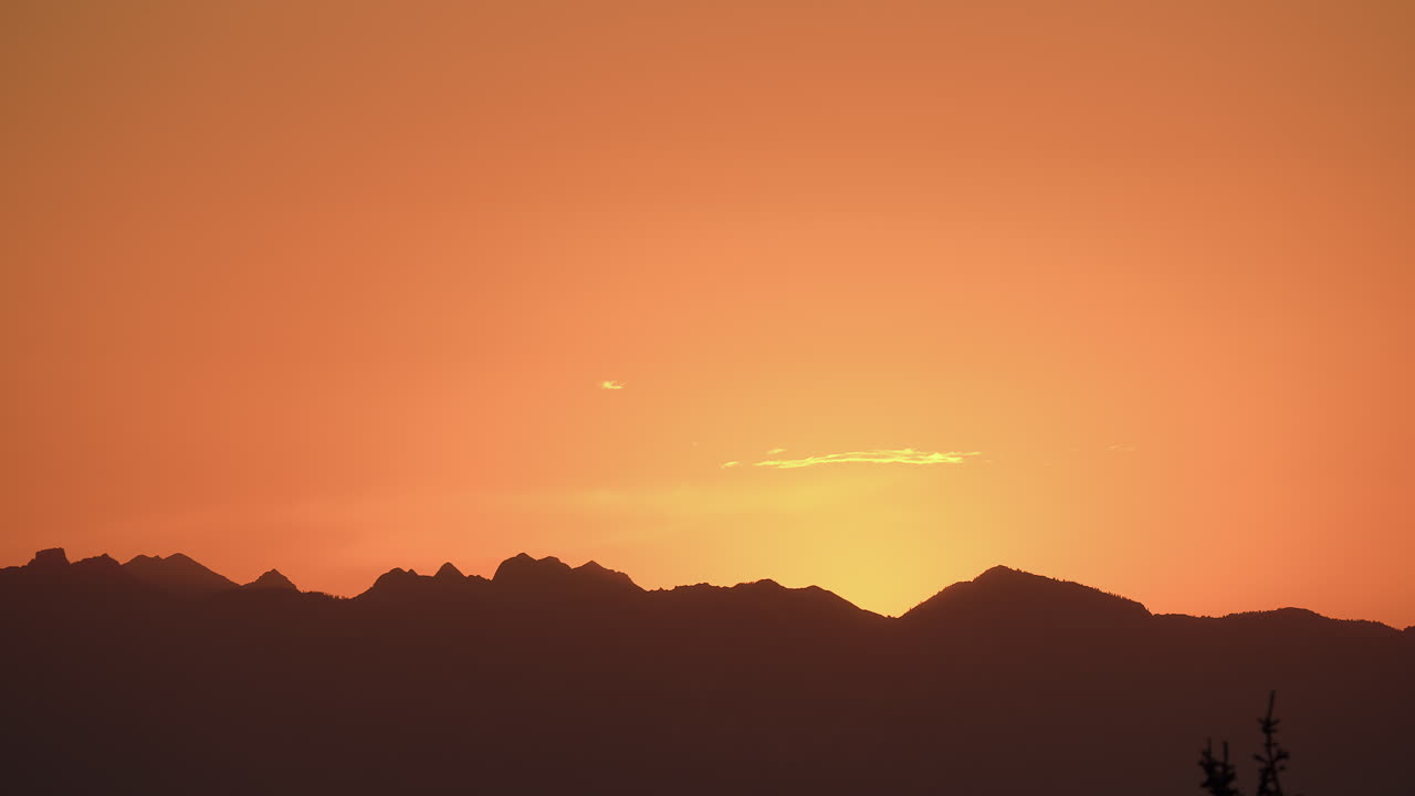 다채로운 해가 지는 하늘을 배경으로 산의 실루.