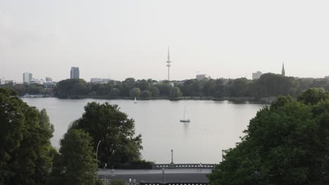 dji mavic 2 pro vuela sobre un mar en hamburgo hacia un puente en primer plano y la torre de televisión en el fondo al atardecer luz ambiental en un caluroso día de verano