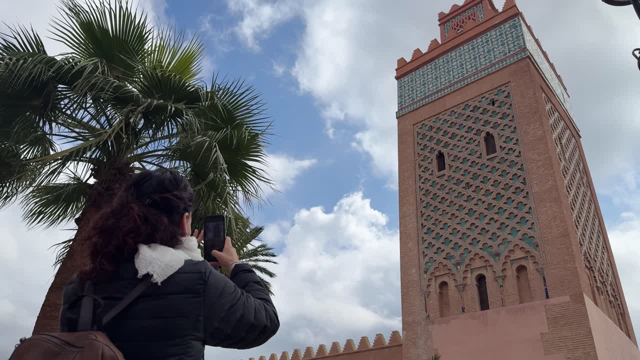 Marakeş'te akıllı telefonla Kutubiye Minaresi'ni çeken kadın.
