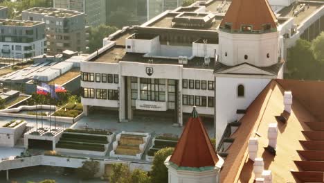 aerial shot of the slovak national council building in bratislava, featuring the modern architecture and surrounding cityscape. captures the essence of slovakia's political hub from above.