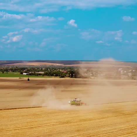 harvesting ripe crop in farmland. large dust from combine harvester on field during agronomy works in rural place. aerial view