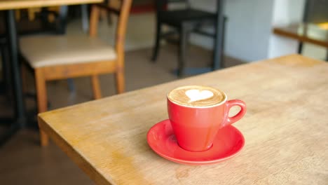 arte de la taza roja de café con leche en una cafetería