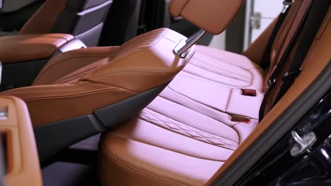 vista cercana del interior de cuero de un coche de lujo, beige. cómodos asientos perforados en un sedán de negocios para un viaje cómodo.