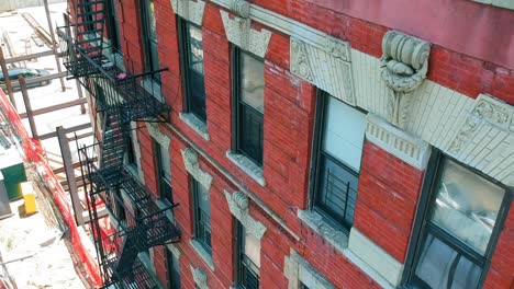 Full-fire-escape-on-side-of-apartment-building-in-NYC-camera-pans-upward-to-roof