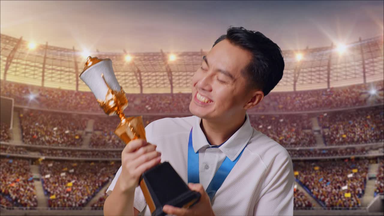 금메달을  아시아 남자가 금메달을 키스하며 스타디움에서 첫 우승자로 자부심을 느다.