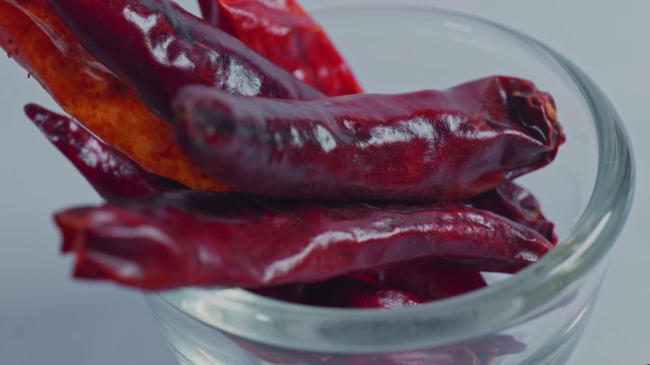 Dried red chilli or Sukhi lal mirch in small glass bowl, 4k, parallax shot.