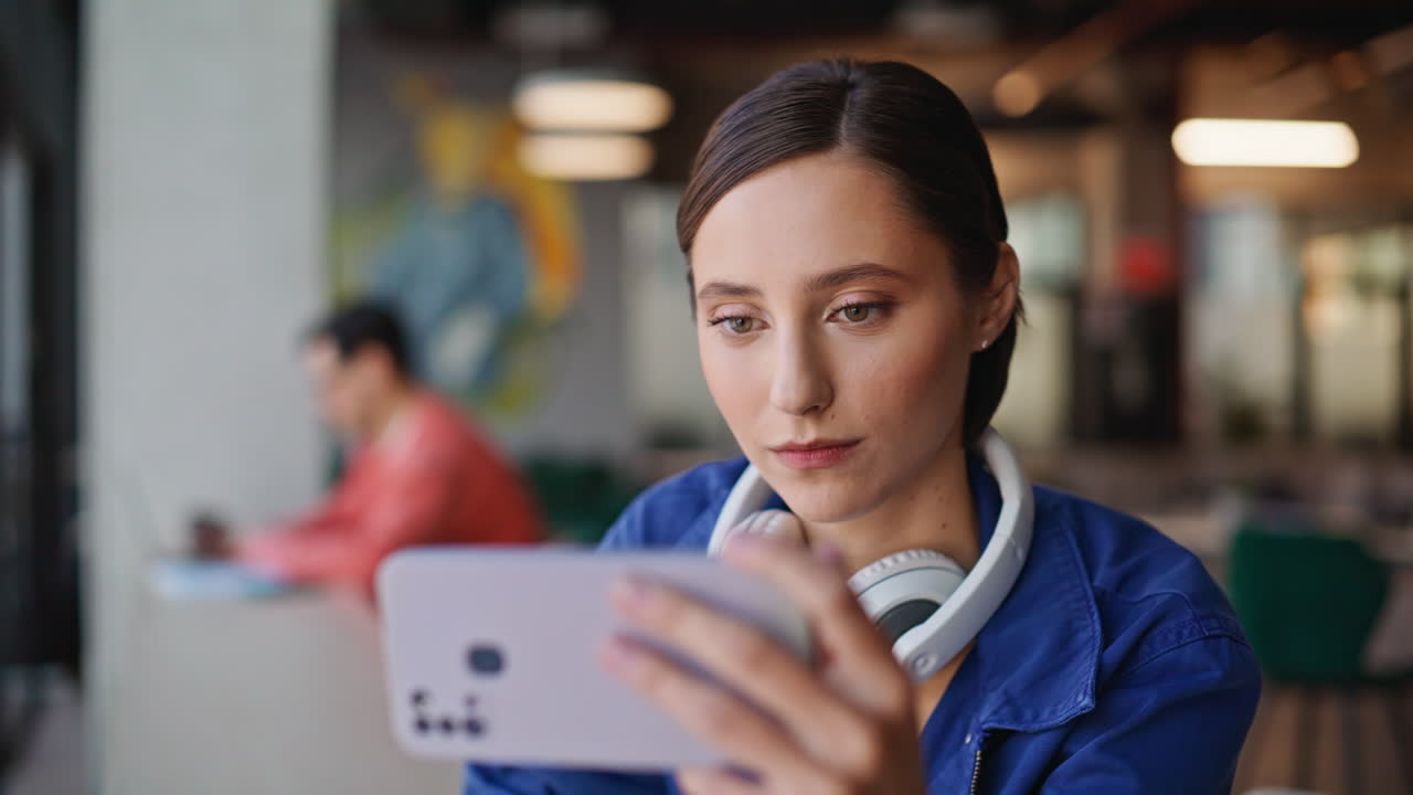 Freelancer watching video mobile phone sitting restaurant closeup. Smiling woman