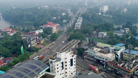 Vista-Aérea-De-La-Ciudad-De-Aluva,-Ernakulam,-La-Línea-De-Inicio-Del-Metro-De-Kochi-Y-El-Puente-Marthanda-Varma