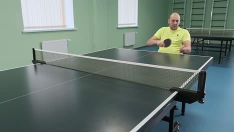 a man in a wheelchair plays ping pong. people with disabilities play table tennis. rehabilitation of the disabled. sport.