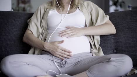 vista frontal de la madre embarazada descansando en el sofá con los ojos cerrados