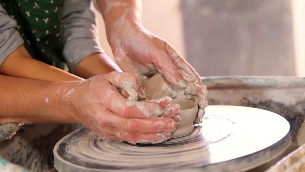 una alfarera ayudando a una niña
