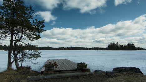 Timelapse-of-clouds-passing-over-lake-of-ice-with-beautiful-pier