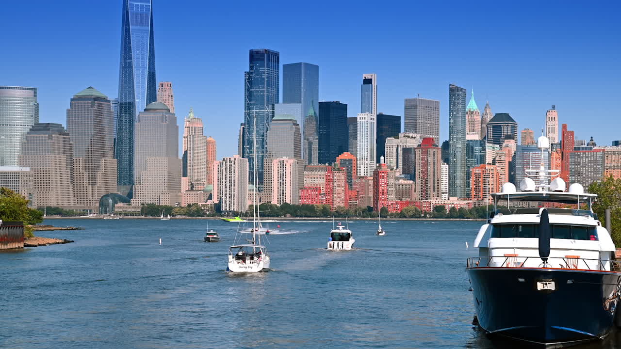 Jersey City, USA, 1 July 2025: Multiple boats and ski jets on the East River. Beautiful skyline of Manhattan at backdrop
