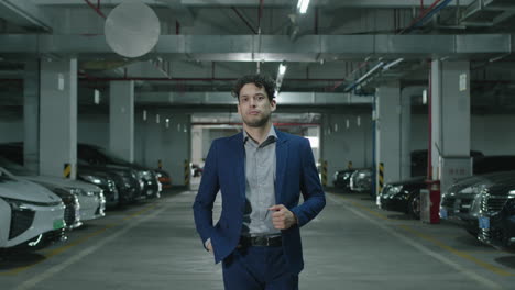 concept of a confident businessman in a suit walking up to the camera looking serious in a parking garage