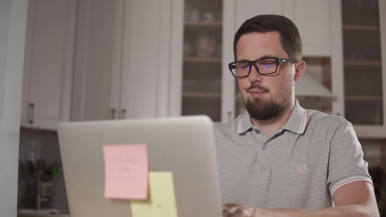 hombre trabajando en una computadora portátil en la cocina