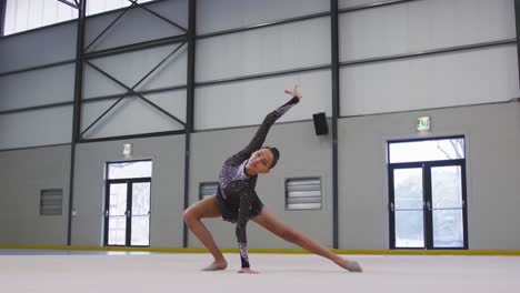gimnasta adolescente actuando en el salón de deportes