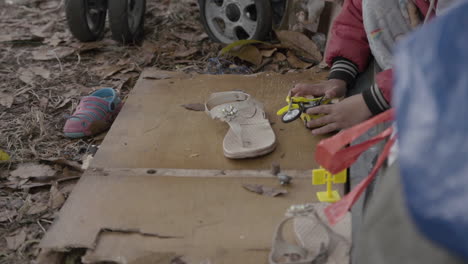 close up of migrant child playing in front of his tent at venezuelan migrant camp in bogota, colombia. because of the covid-19 crisis many try to return to their country.