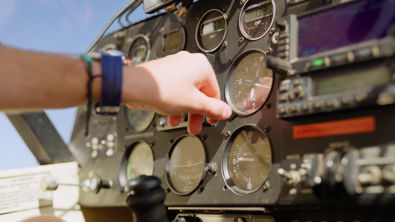 Pilota che regola l'altimetro sul quadro strumenti dell'aereo.