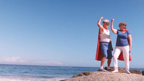 Pareja-Mayor-Flexionando-Los-Brazos-En-La-Playa