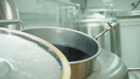 craft beer production factory, brewery manufacture. putting barley malt grains close-up. brewing, cooking alcohol in metal vats bottles