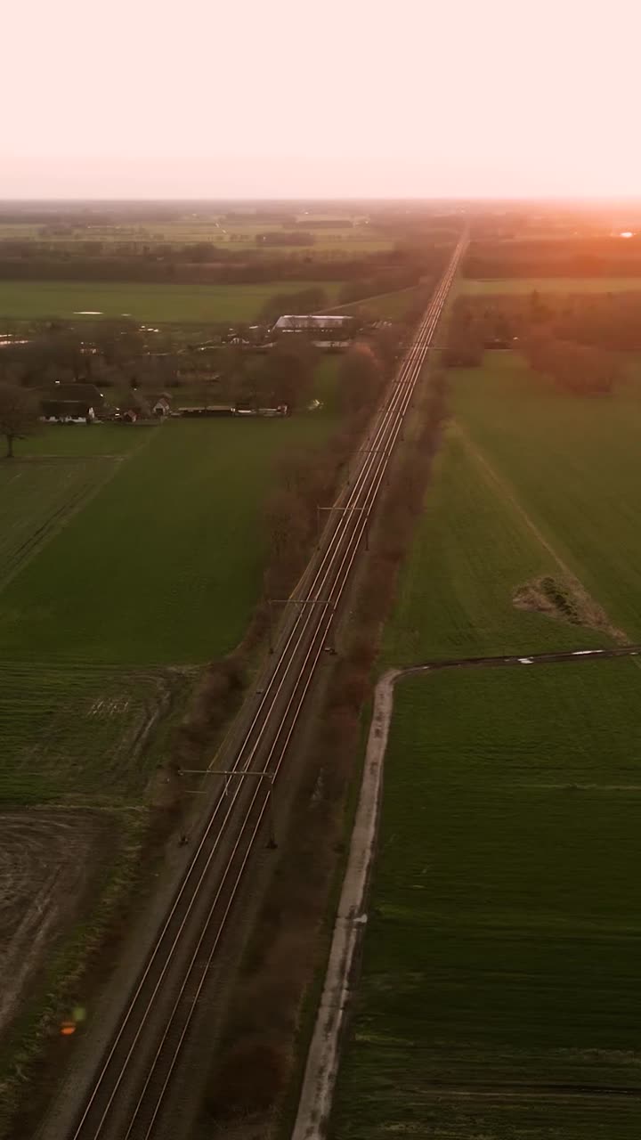 기차 철도와 농경지 위의 해가 지는 모습